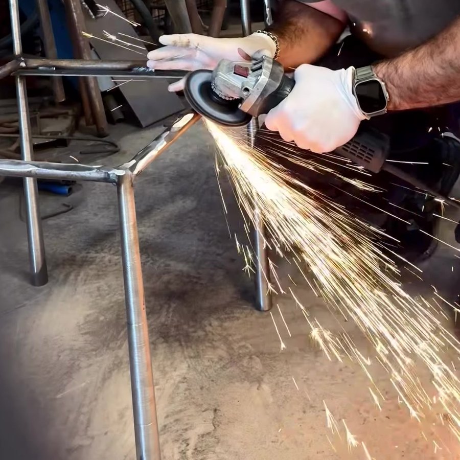 Grinding a steel chair frame with an angle grinder